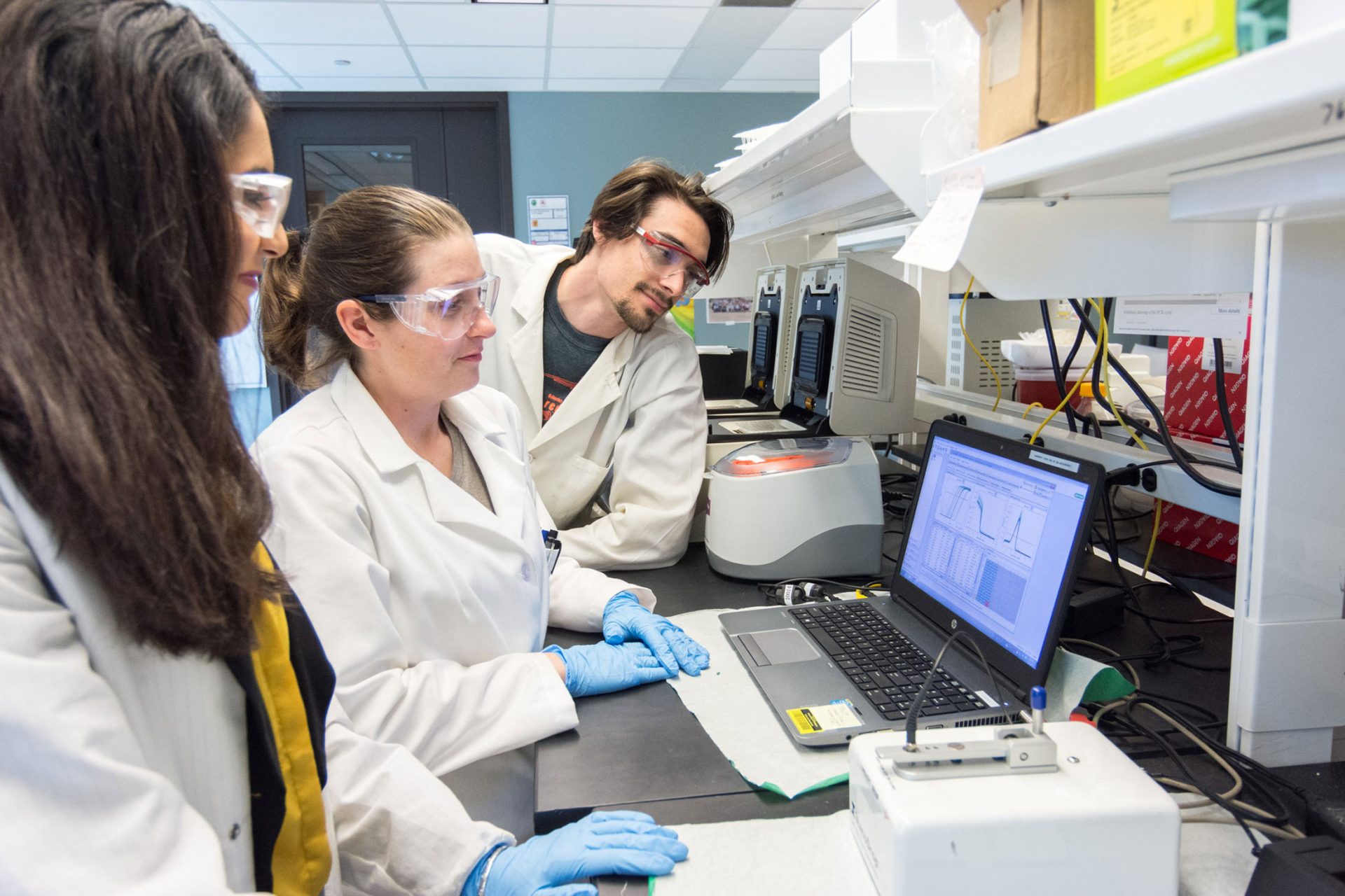 Three people working together in a lab.